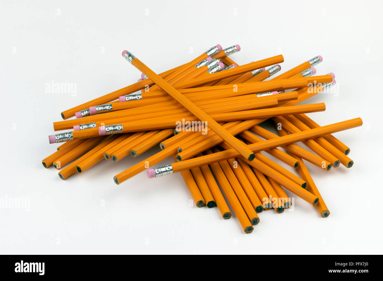 A jumbled, disorganized stack of unsharpened, orange, six-sided pencils ready to be sharpened for writing at school or in an office. Stock Photo