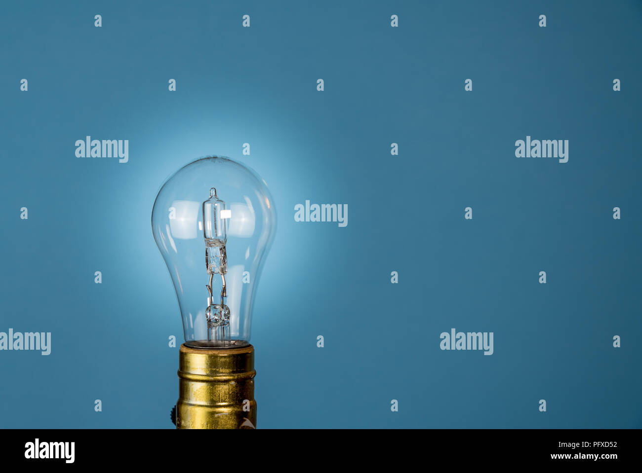 Halogen lightbulb against a blue background Stock Photo