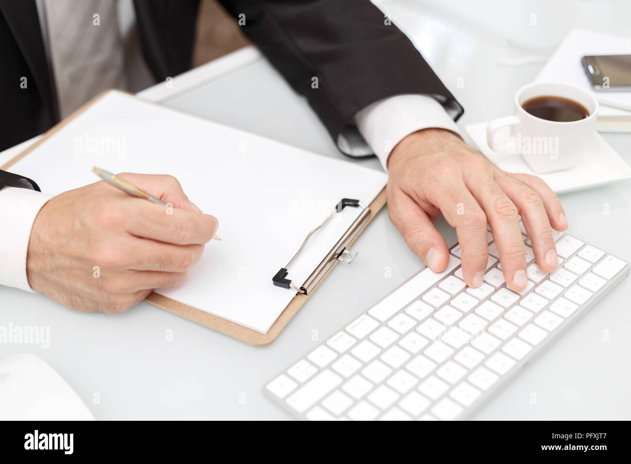 Male hands using modern computer and writing with pen business concept ...