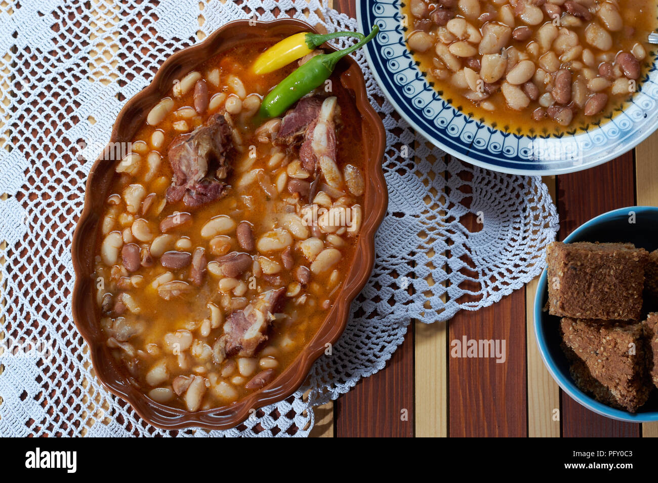 Beans with smoked pork on dinner plate with spelta bread Stock Photo