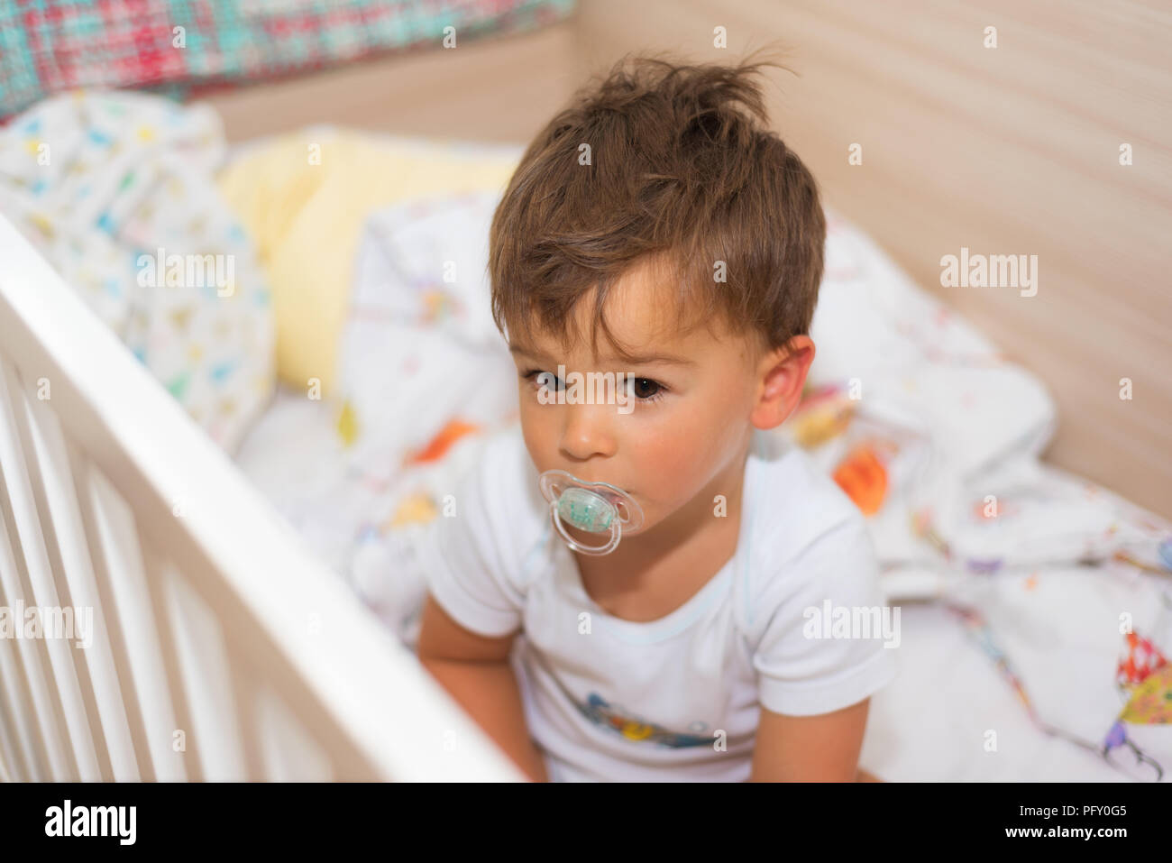 Adorable little boy in the crib with pacifier Stock Photo Alamy