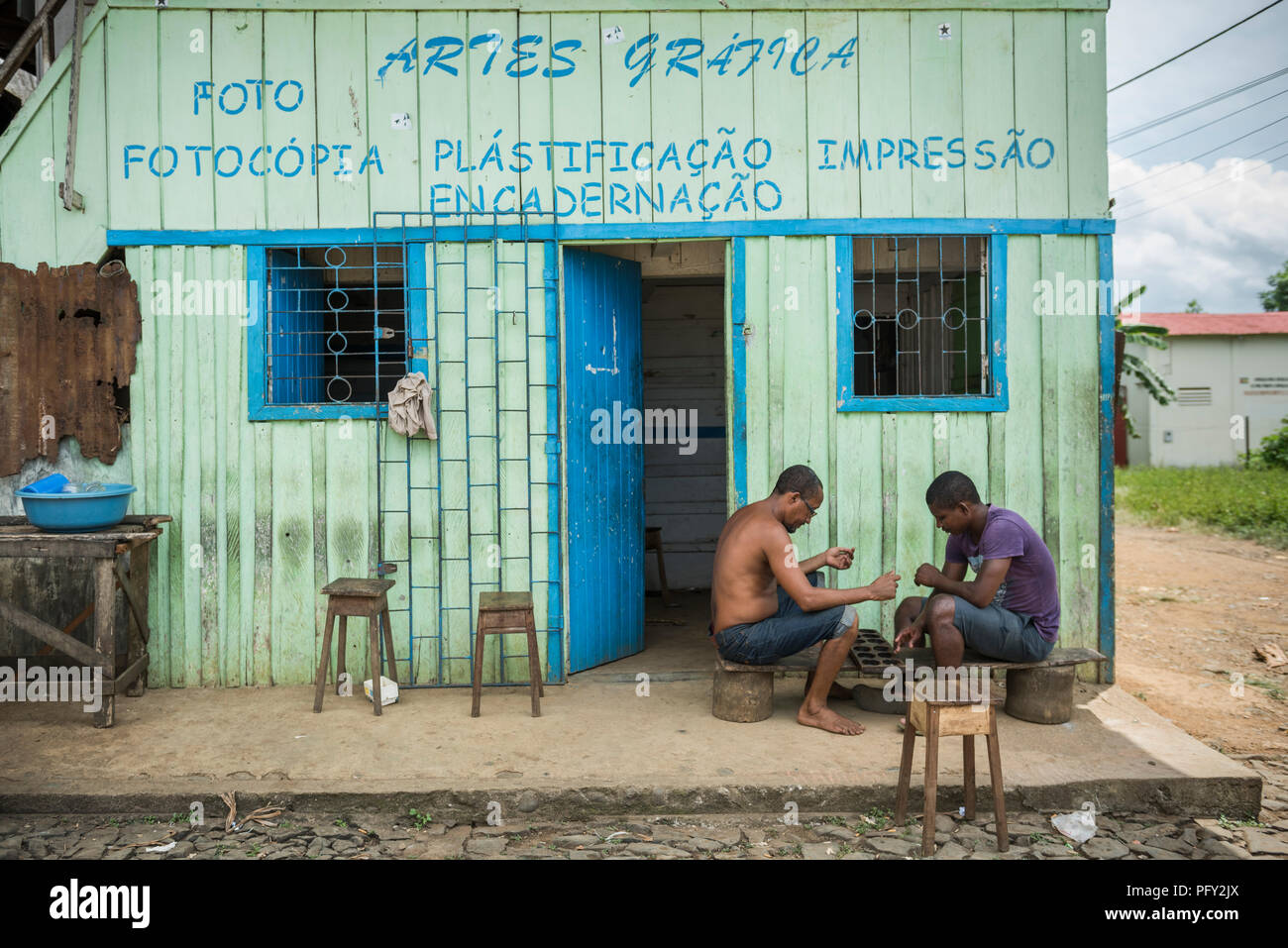 Men play a board game in front of a shop, Roça Água Ize, São Tomé