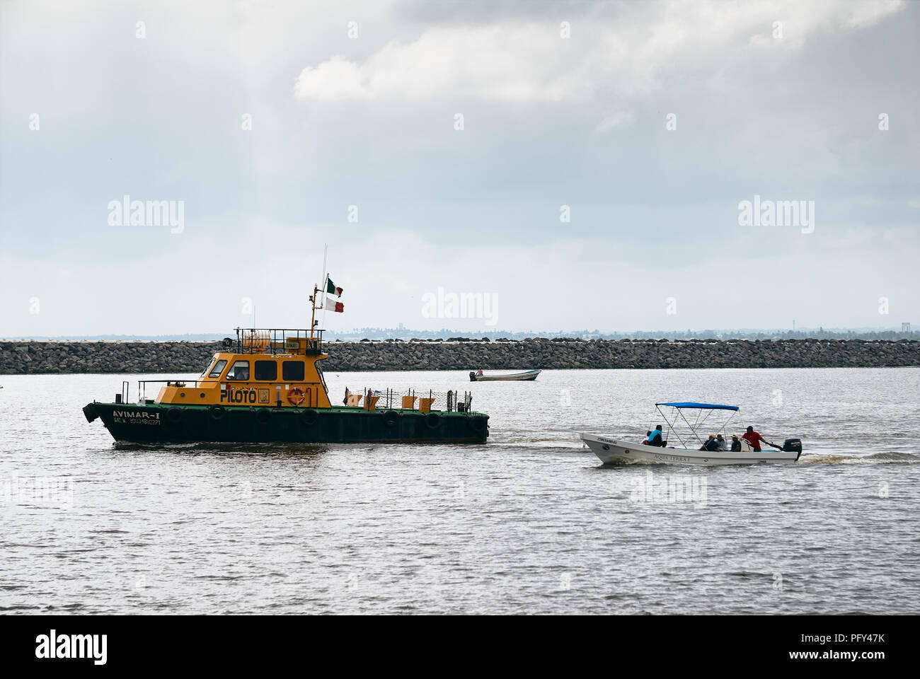 COATZACOALCOS, VER/MEXICO - AUG 18, 2018: A maritime pilot ship, Avimar-1, at the breakwaters on the river mouth. A water taxi and a fishing boat Stock Photo