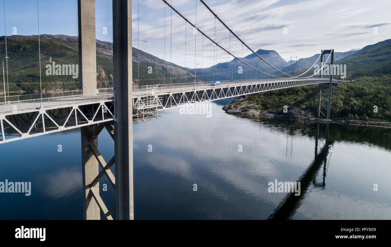 Aerial shot of bridge Rombaksbrua over Straumen bay of Ofotfjord. Cars on bridge and mountains in background. Narvik, Norway Stock Photo