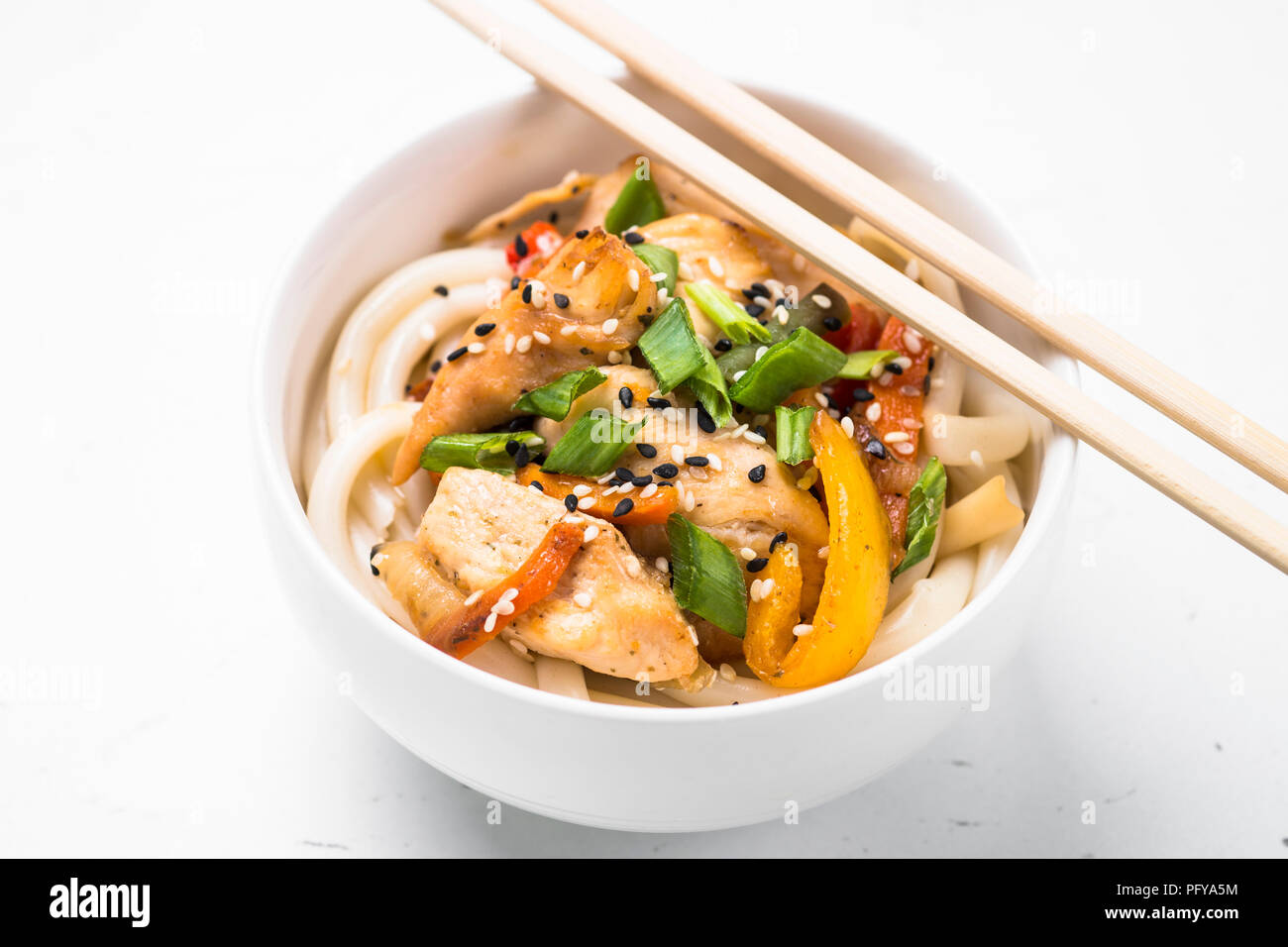 Udon stir-fry noodles with chicken and vegetables on white Stock Photo ...