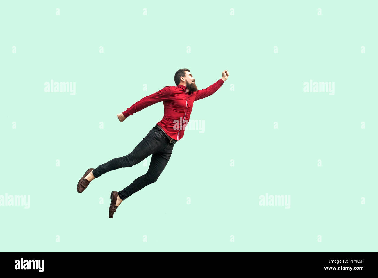 Superman style. Enthusiasm concept. strong bearded businessman felt himself a superhero and flying up. indoor studio shot isolated on light green back Stock Photo