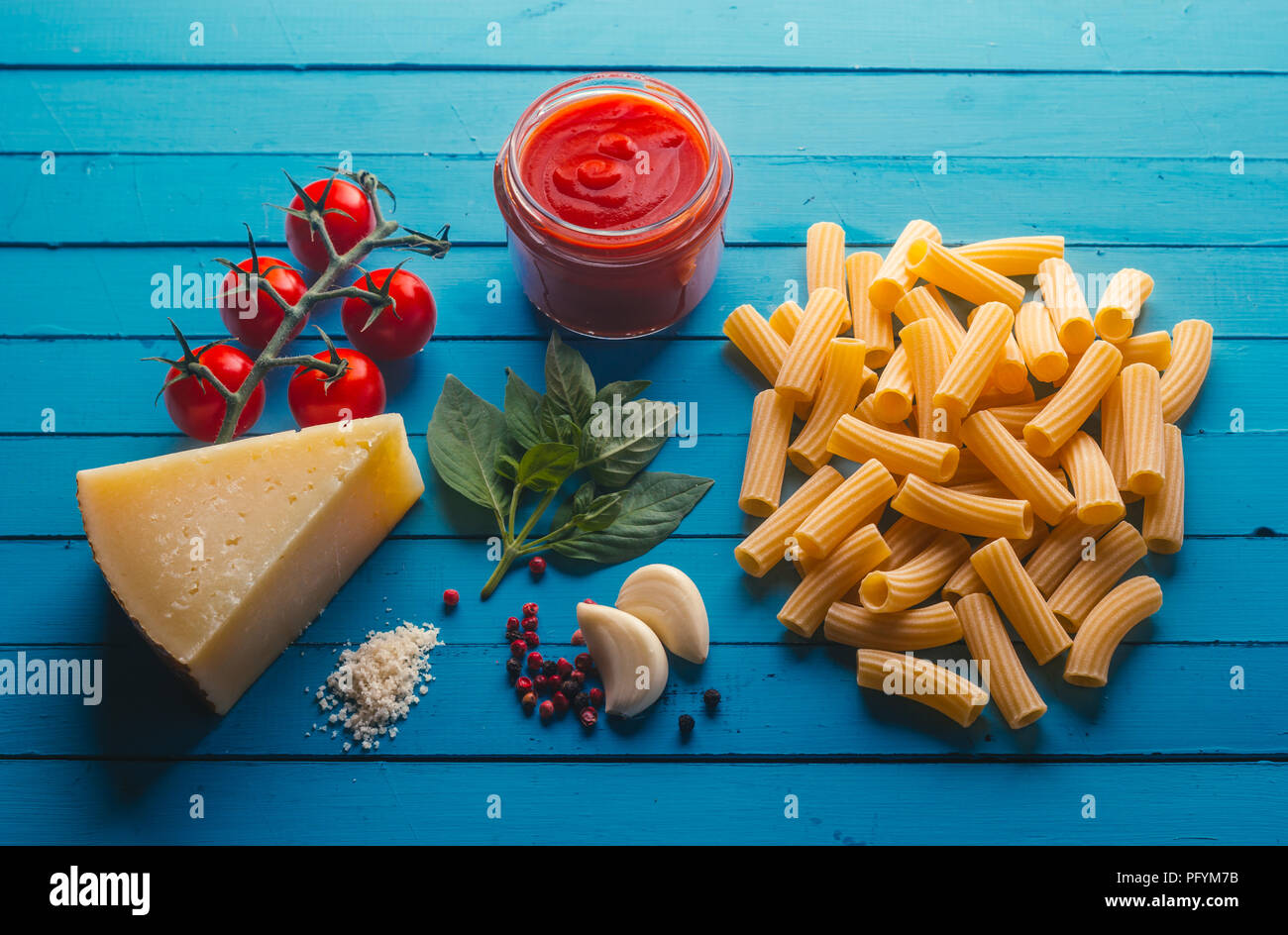 Pasta with various ingredients for cooking Italian food, on a blue table Stock Photo