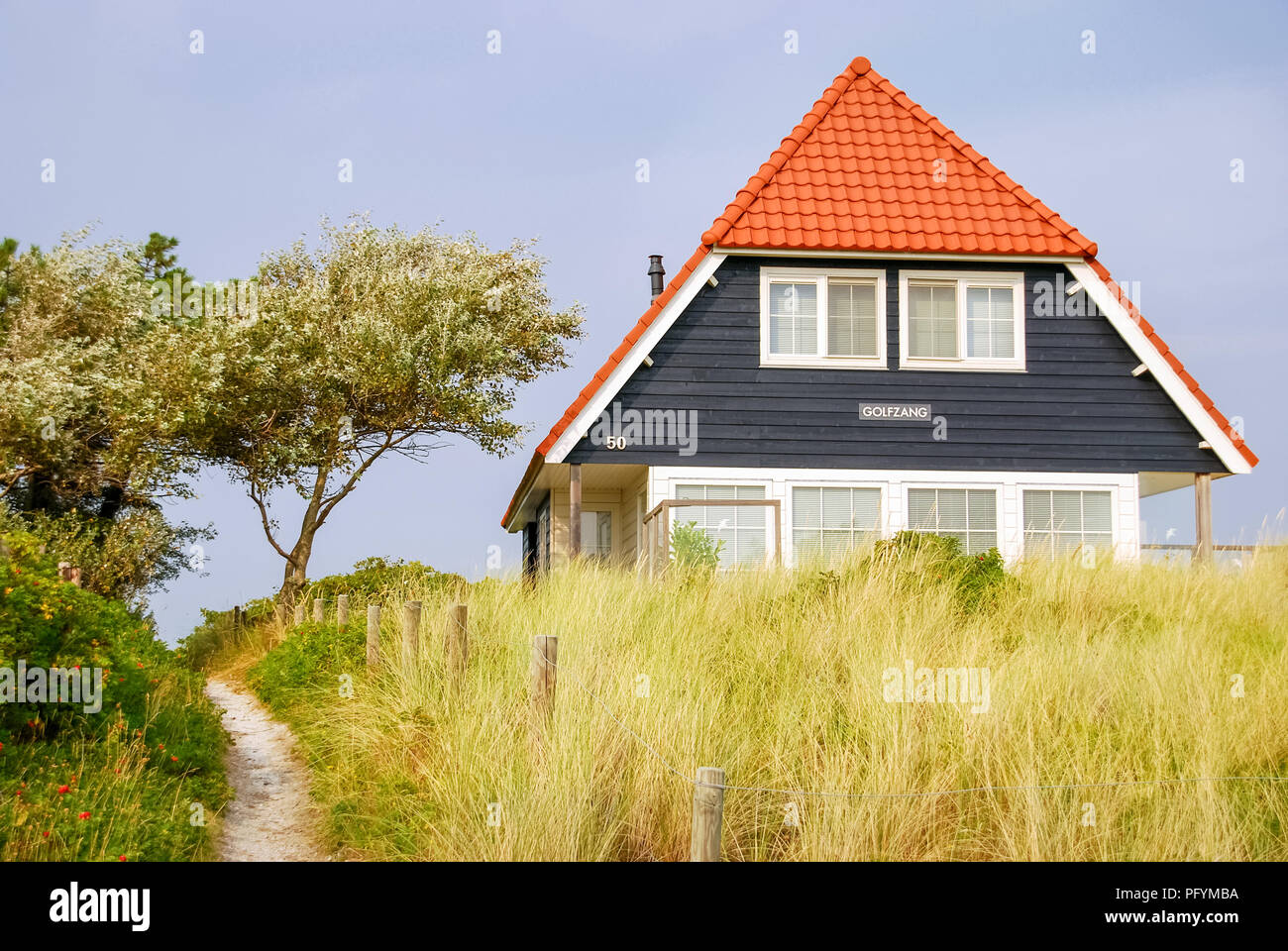 A blue house and the Dutch flag on the Frisian Island of Vlieland, The Netherlands. The Frisian Islands, are also known as the Wadden Islands Stock Photo