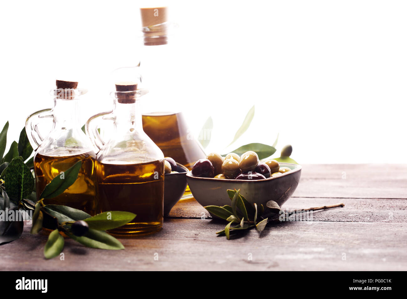Bottle virgin olive oil and oil in a bowl with some olives Stock Photo ...