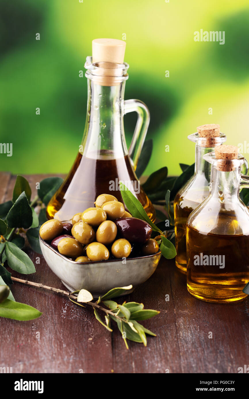 Bottle virgin olive oil and oil in a bowl with some olives Stock Photo ...