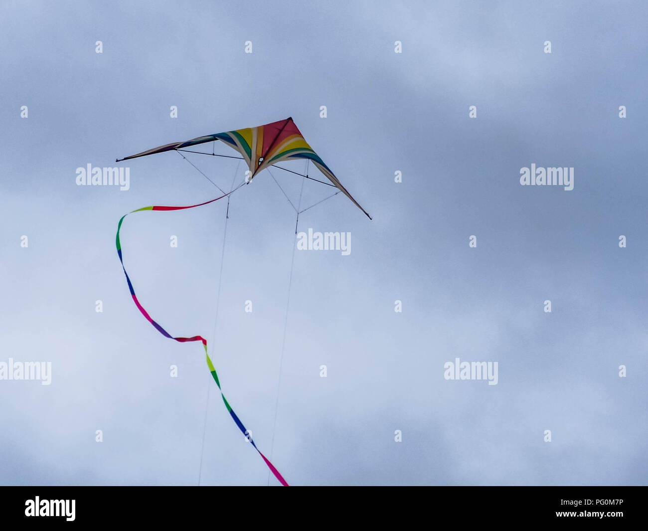 A Kite flying against a cloudy sky Stock Photo