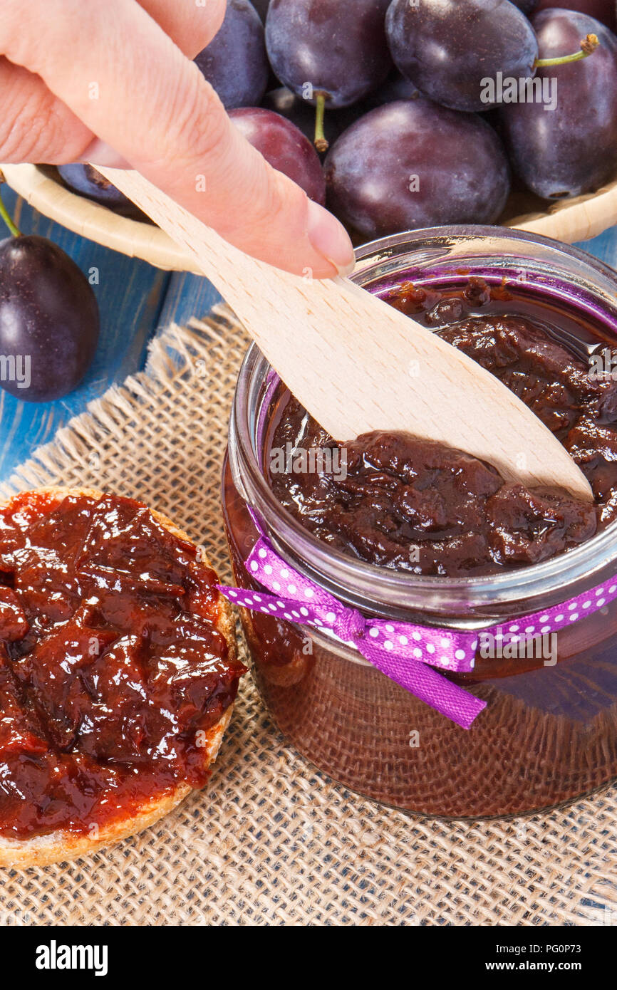 Preparing sandwiches with homemade plum marmalade or jam, concept of healthy sweet snack, breakfast or dessert Stock Photo