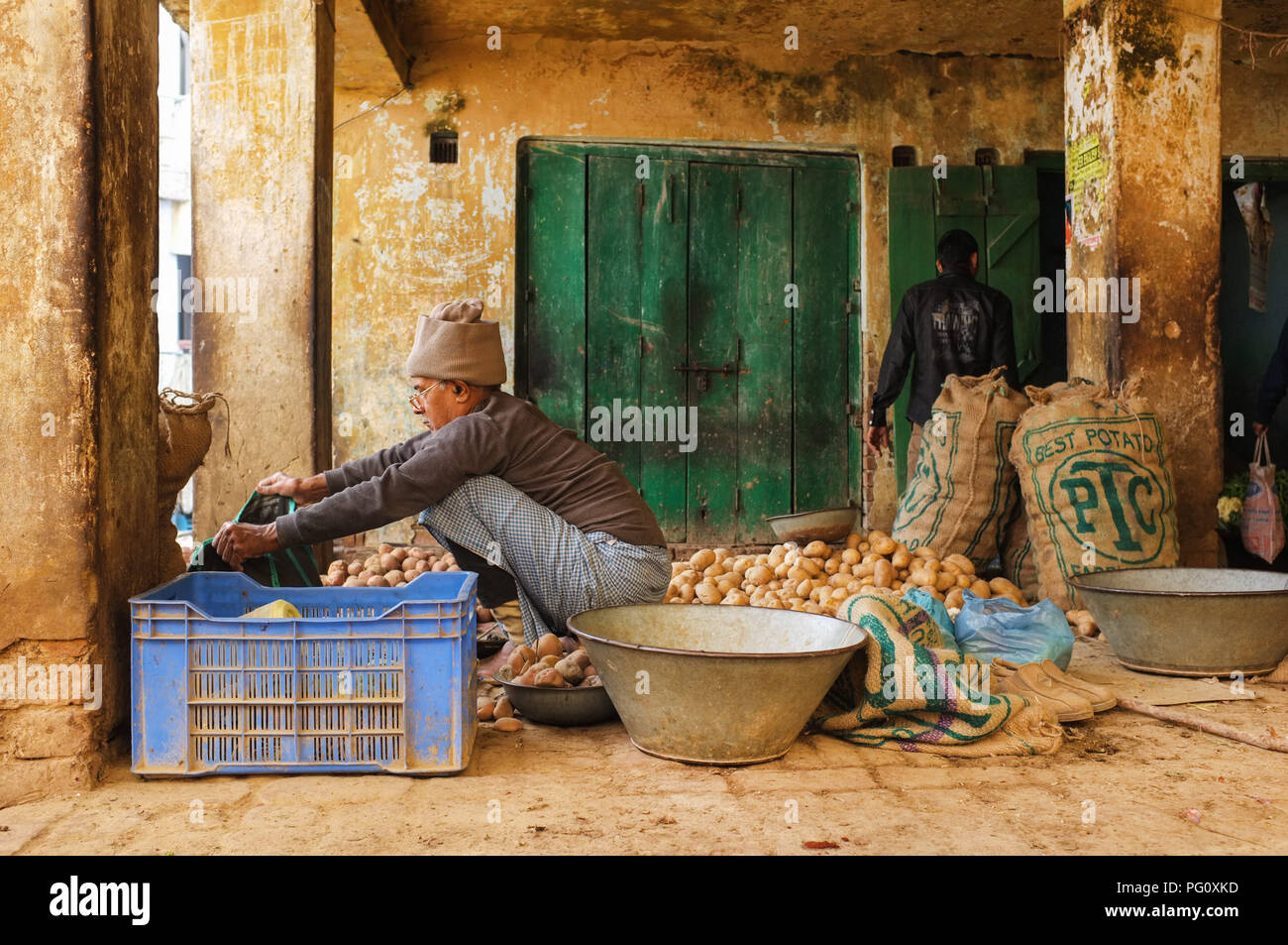 VARANASI, INDIA - FEBRUARY 20, 2015: Street vendor prepares his shop for selling his potato produce. Stock Photo