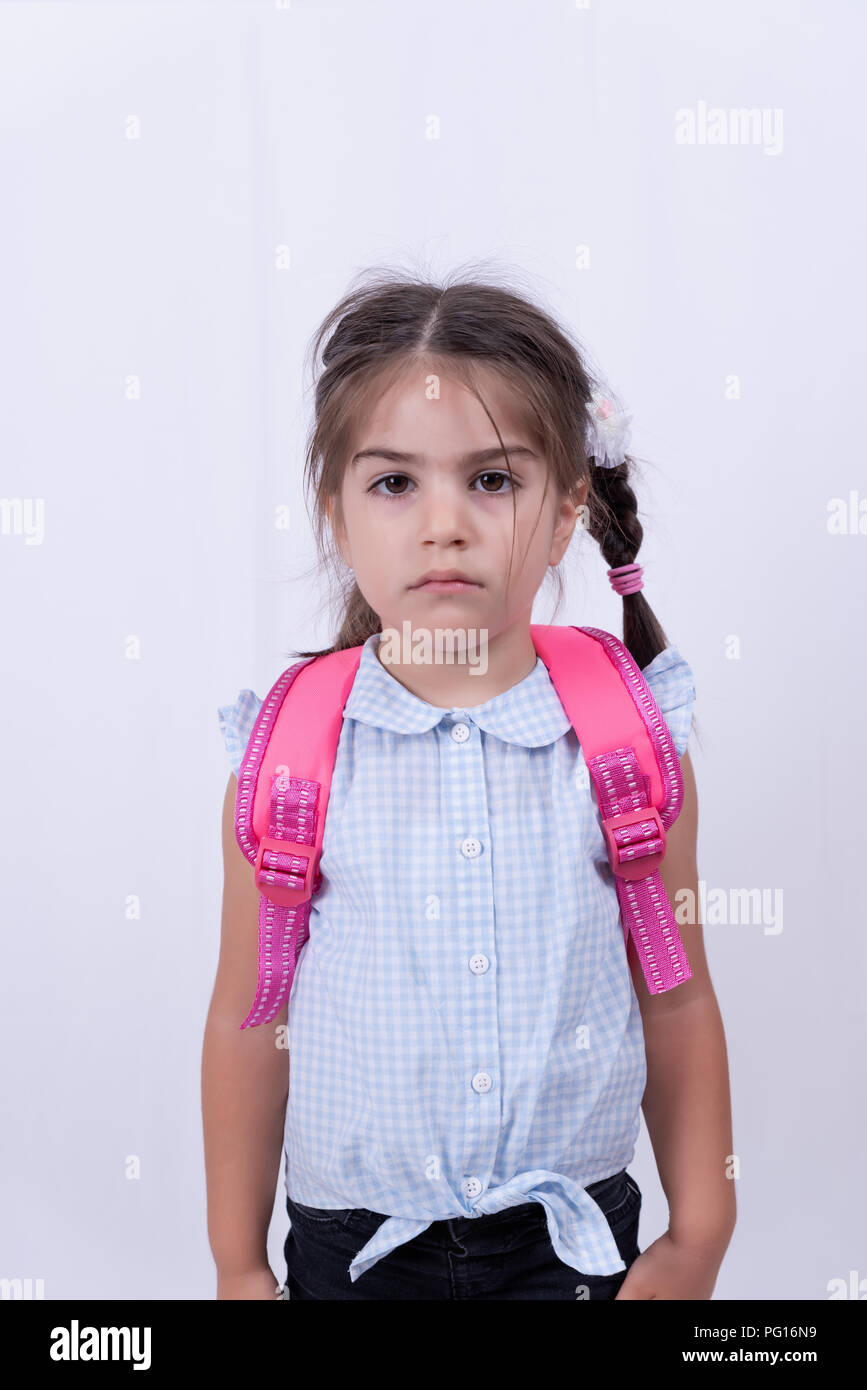 Portrait of cute unhappy girl in school uniform not want to go school
