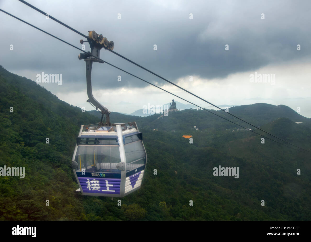 08.07.2018 Cable Car way to mountains ngong ping in the background a big buddha Stock Photo