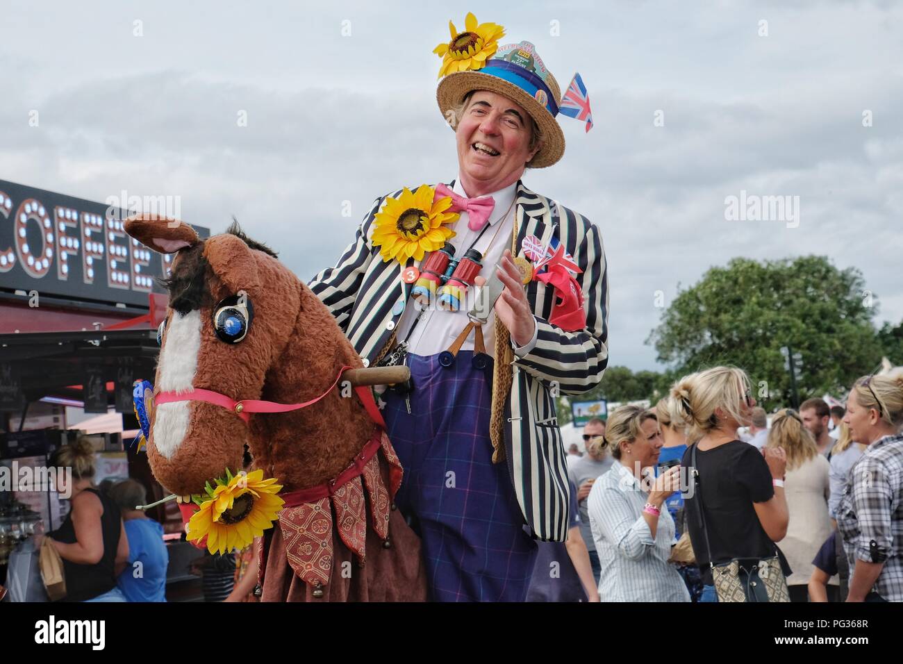 Melplash Agricultural Show, Bridport, Dorset, UK. 23 August 2018. Visitors enjoy one of the performance artists at the Melplash Agricultural Show in Bridport, Dorset.The one day agricultural show is a showcase and celebration for local farmers, producers, growers and craftspeople and is the South West’s premier agricultural exhibition. Credit Tom Corban/Alamy Live News. Stock Photo