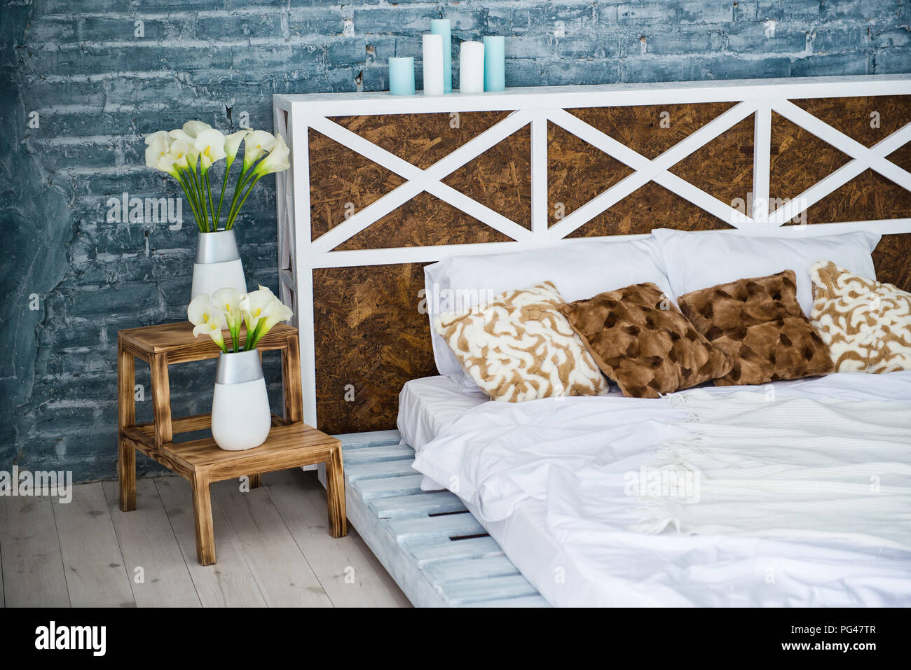 Bedroom with double bed, brick gray wall, loft style. Stock Photo