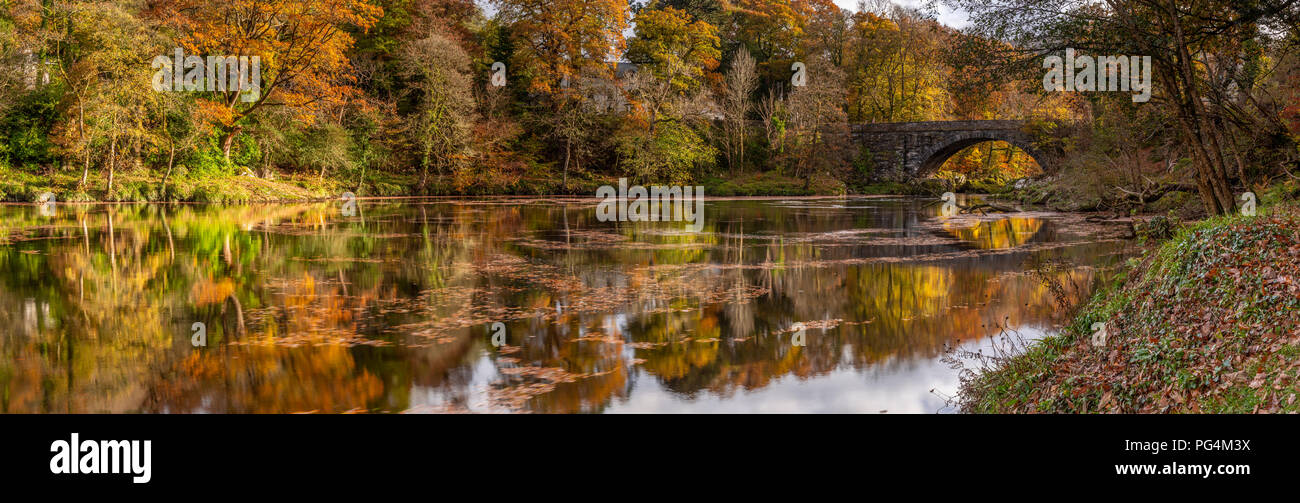 Old stone bridge reflecting in the river Conwy, North Wales in autumn near Betws-y-Coed, Snowdonia Stock Photo