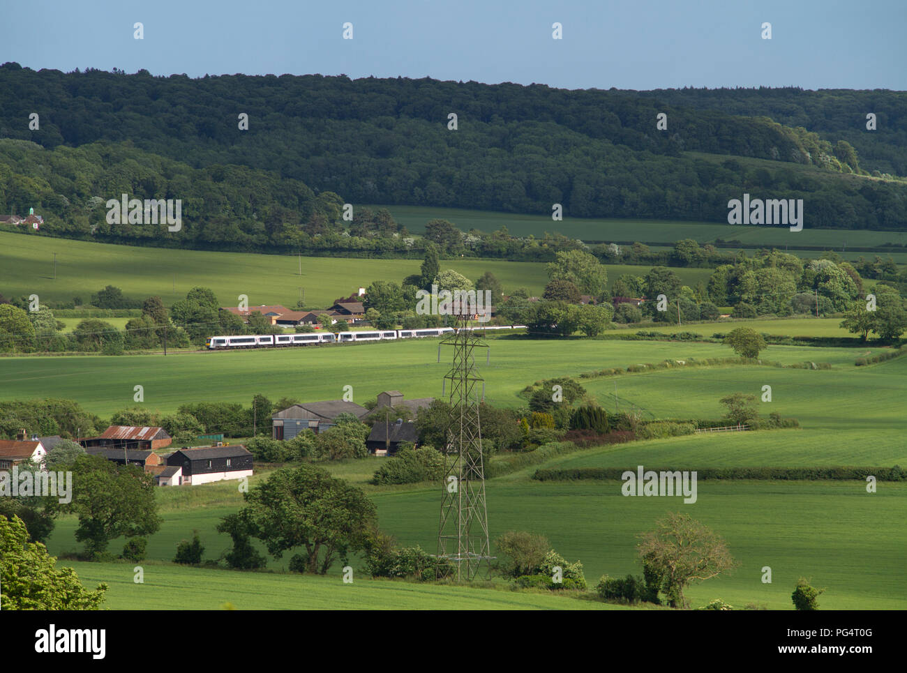 A trio of Chiltern Railways Class 168 Clubman DMUs heads north through the Chiltern Hills in Buckinghamshire, seen from Lodge Hill near Saunderton. Stock Photo