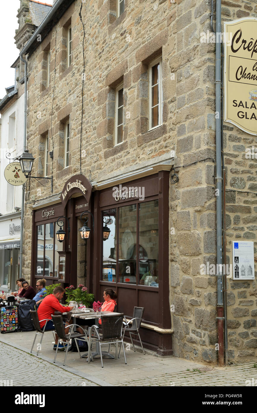 View of café and patrons seated outside in Rue Admiral Reveillere, Roscoff, Finistere, Brittany, France Stock Photo