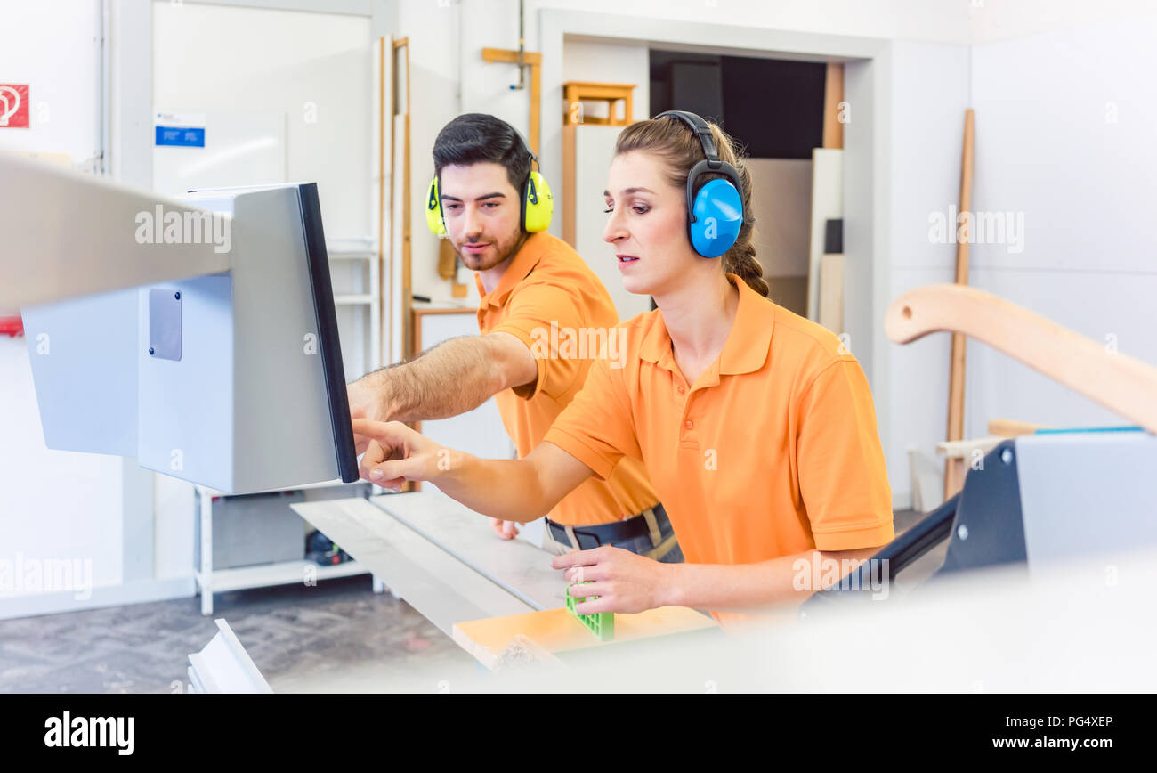 Carpenter programming computer controlled saw Stock Photo Alamy