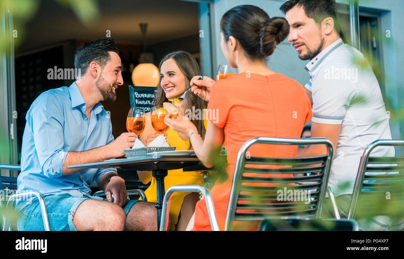 Cheerful friends toasting with a refreshing summer drink at a tr Stock Photo