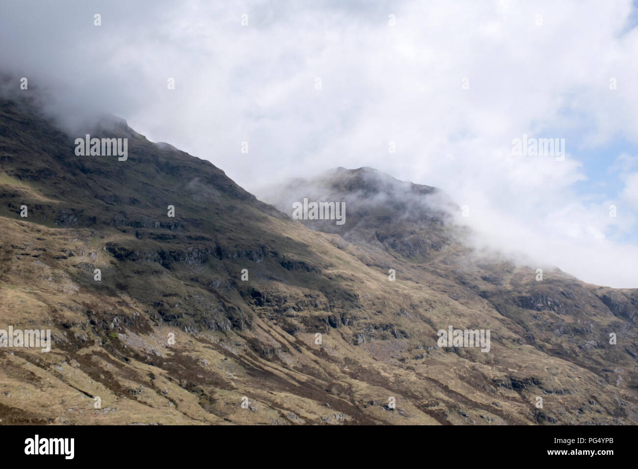 a shot of clouds clashing unto the mountain side of an irish landscape Stock Photo