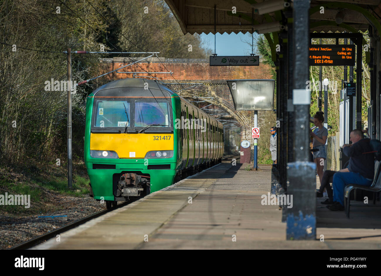Class 321 passenger train in London Midland livery arriving at a small ...