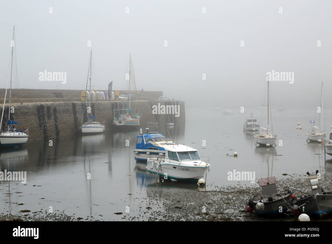 Fog and low tide in the marina at Quai Charles de Gaulle, Roscoff, Finistere, Brittany, France Stock Photo