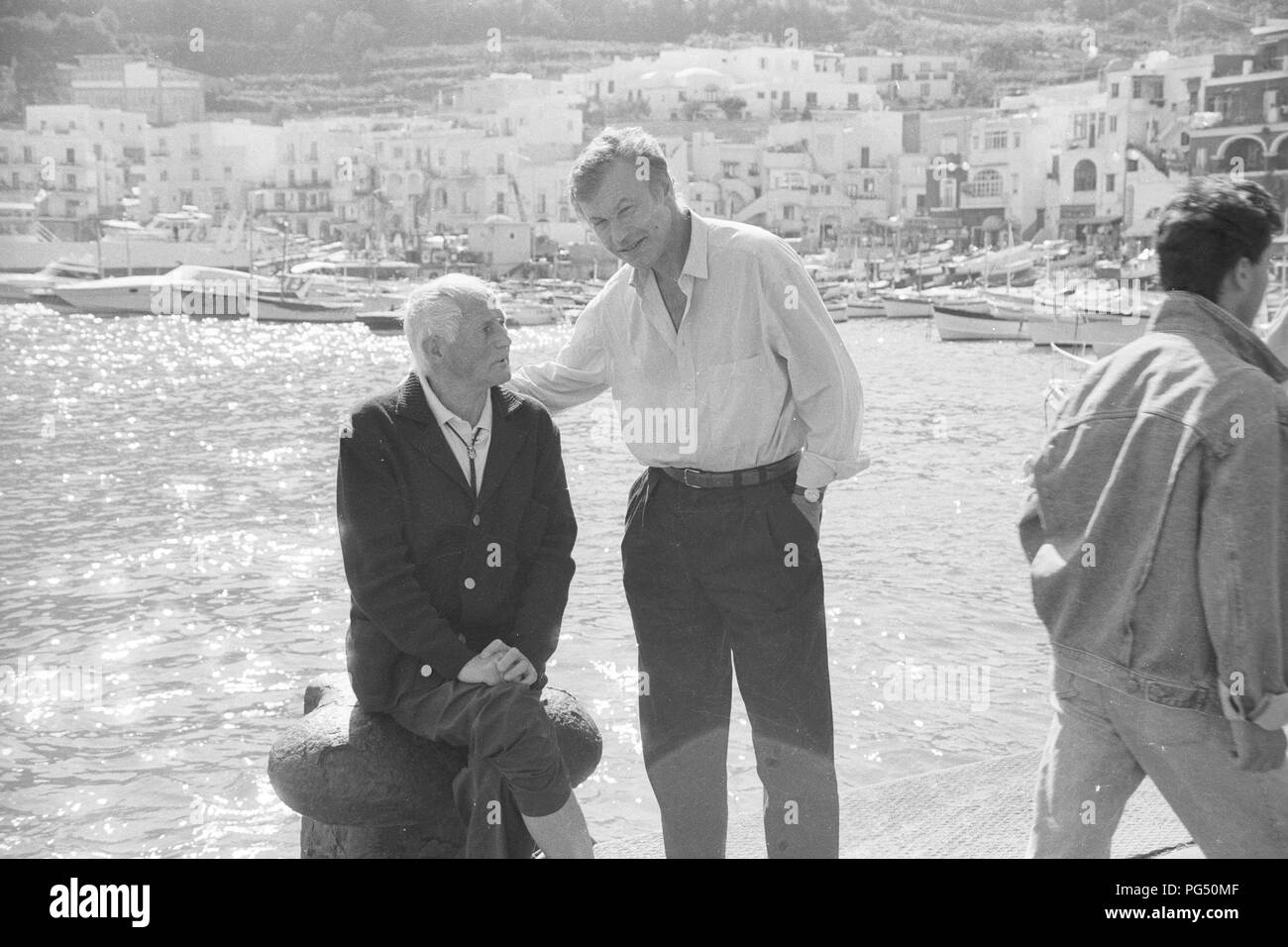 The Czech writer Bohumil Hrabal sits on a bollard in the harbor of the Italian island of Capri. Stock Photo