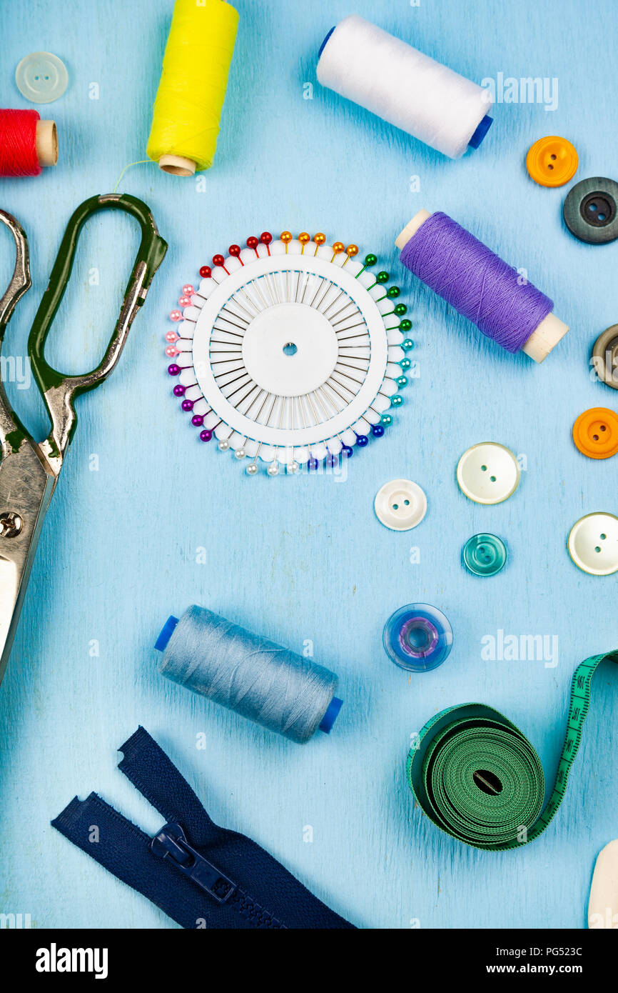 Sewing accessories on a blue wooden background. Measuring tape, pins ...
