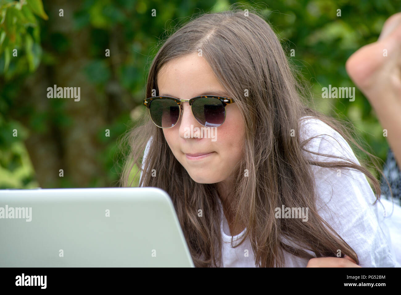 a teenage girl using laptop in the garden Stock Photo - Alamy