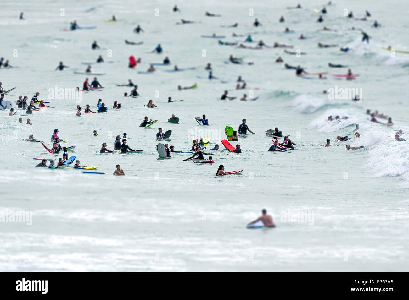 Holidaymakers have fun in the sea at Fistral in Newquay Cornwall. Stock Photo