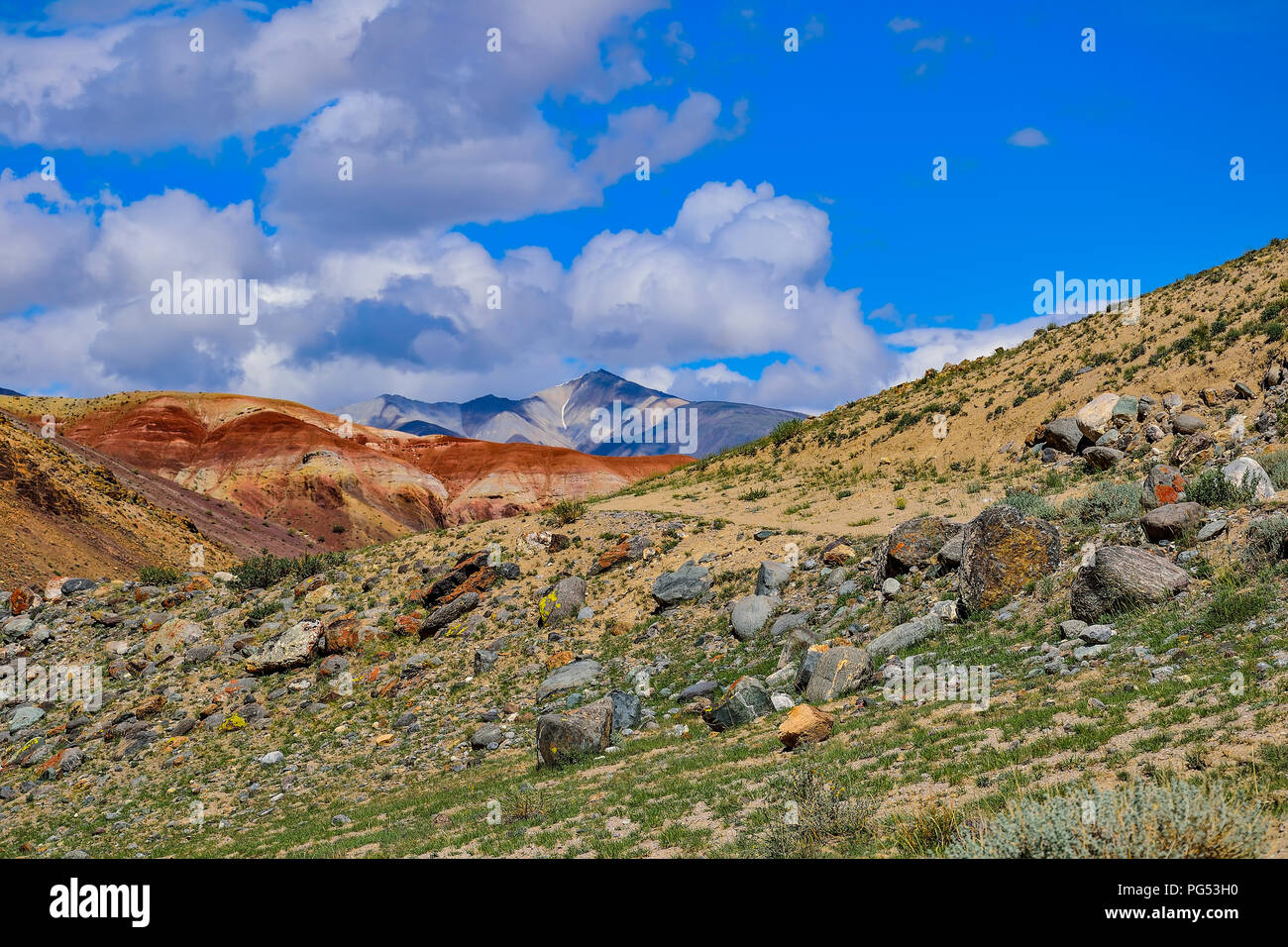 View of unrealy beautiful multicolored clay cliffs Kyzyl Chin and Kuray range on background, Altai mountains, Russia Stock Photo