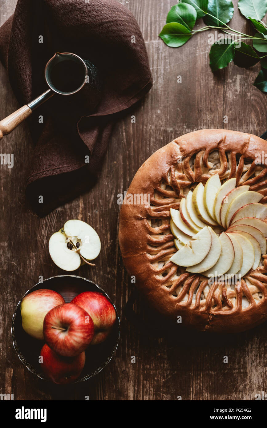 flat lay with homemade apple pie, coffee maker and fresh apples on wooden tabletop Stock Photo