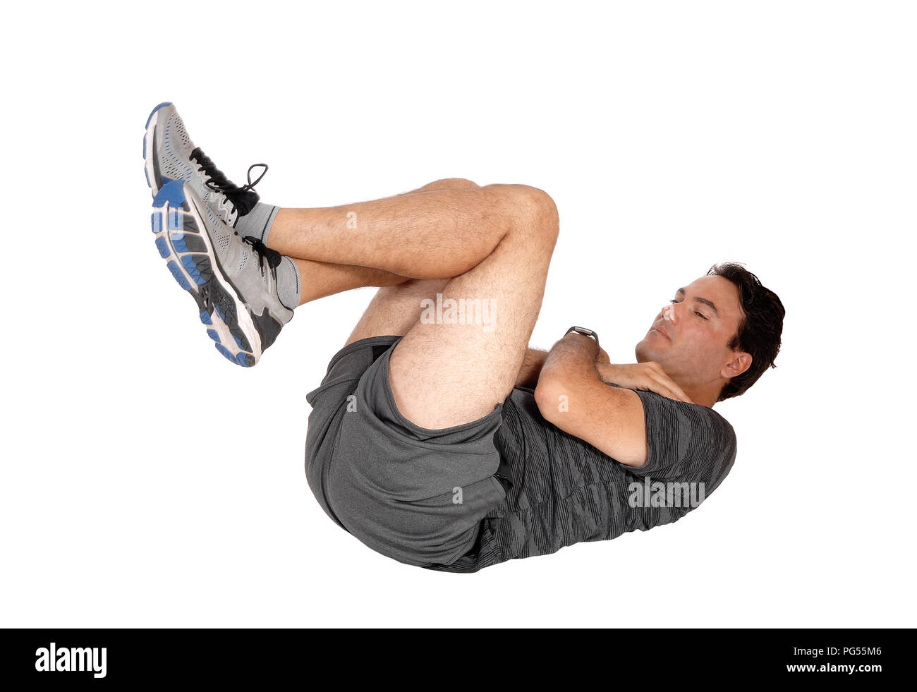 A young tall man lying on the floor doing his exercise in sit ups in shorts and sneakers isolated for white background Stock Photo Alamy