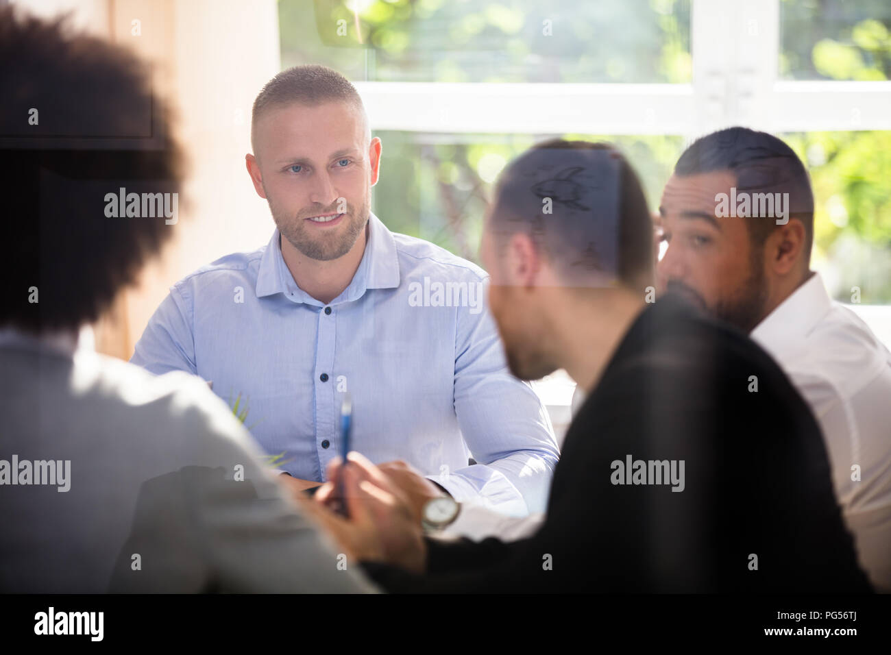 Group Of Businesspeople Sitting In Office During Business Meeting Stock ...