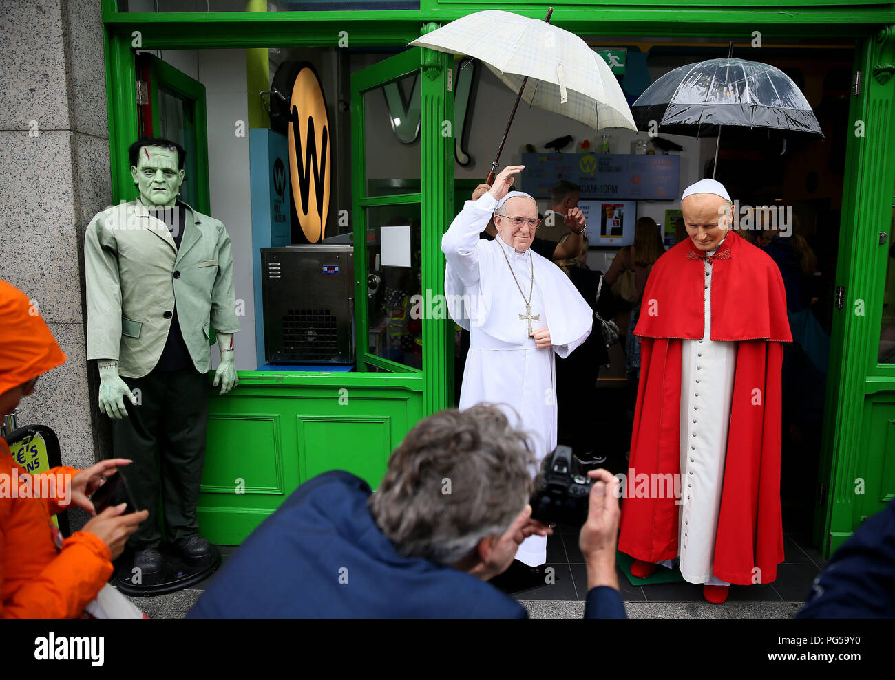 People photograph a newly unveiled wax work of Pope Francis (left) and the waxwork of Pope John Paul II at the National Wax Museum Plus in Dublin where they also unveiled a newly refurbished original 1979 Pope Mobile ahead of Pope Francis Visit To Ireland. Stock Photo