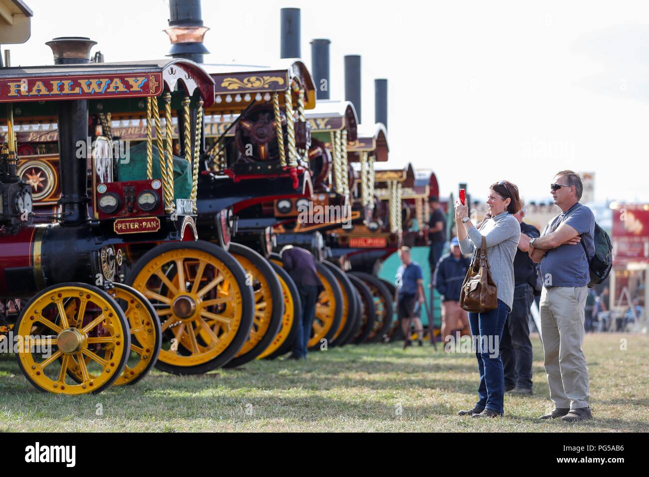 Visitors take photographs of a line of Burrell Showman's Road Locomotives at the Great Dorset Steam Fair, at Tarrant Hinton, near Blandford Forum, where hundreds of steam-driven traction engines and heavy mechanical equipment from all eras, gather for the annual show which runs until Bank Holiday Monday and this year celebrates its 50th anniversary. Stock Photo
