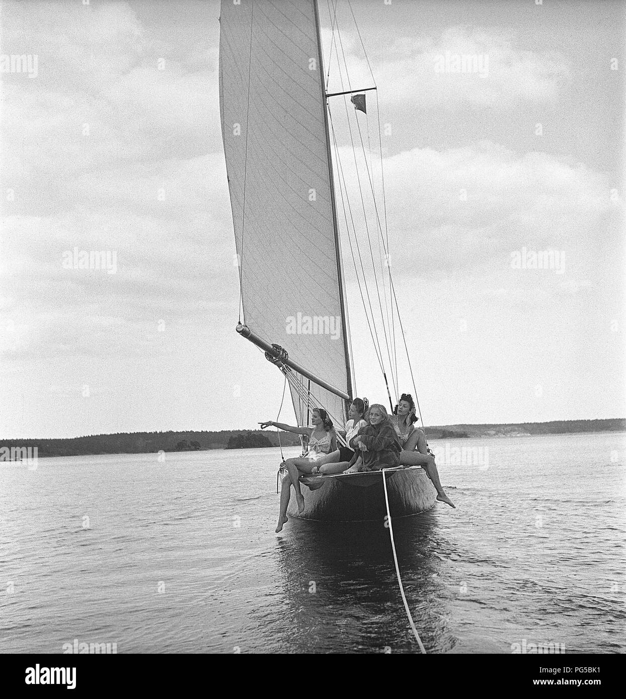 1940s boating. Four young women are on board a fashionable sailing boat ...