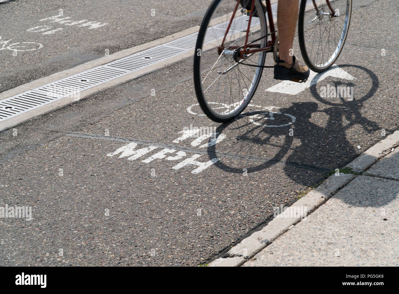 10 MPH bike lane direction sign painted on roadway in urban city street