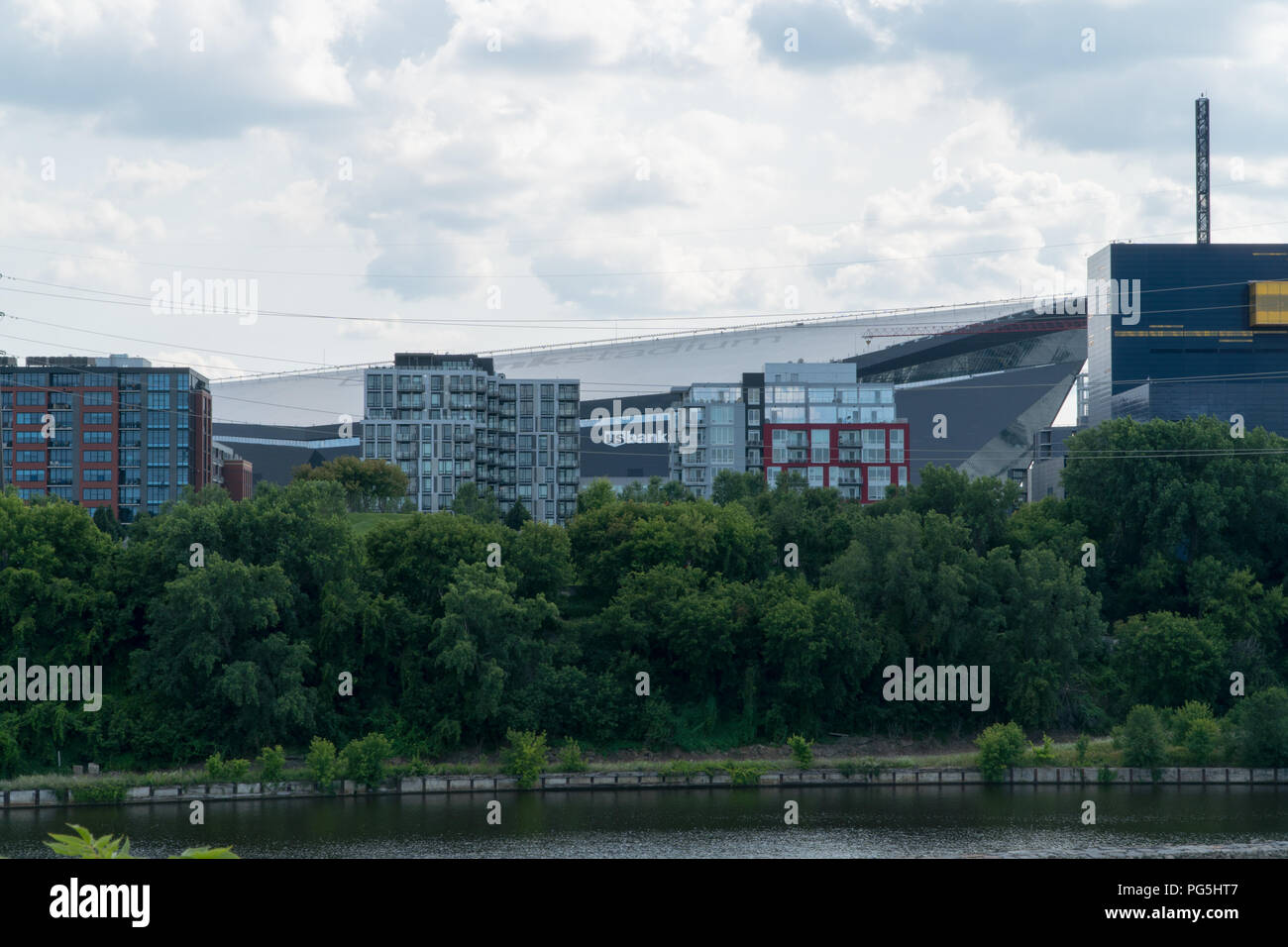 Minneapolis USA - Circa 2018: US Bank Stadium behind the Mississippi River waterfront skyline on a summer day. Home to Minnesota Vikings football team Stock Photo