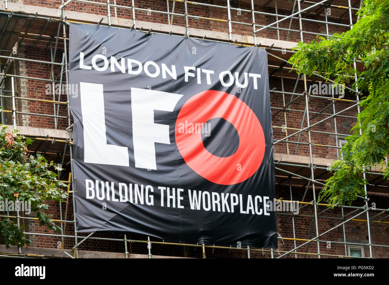 A banner on scaffolding advertising London Fit Out an office fit out and refurbishment company. Stock Photo