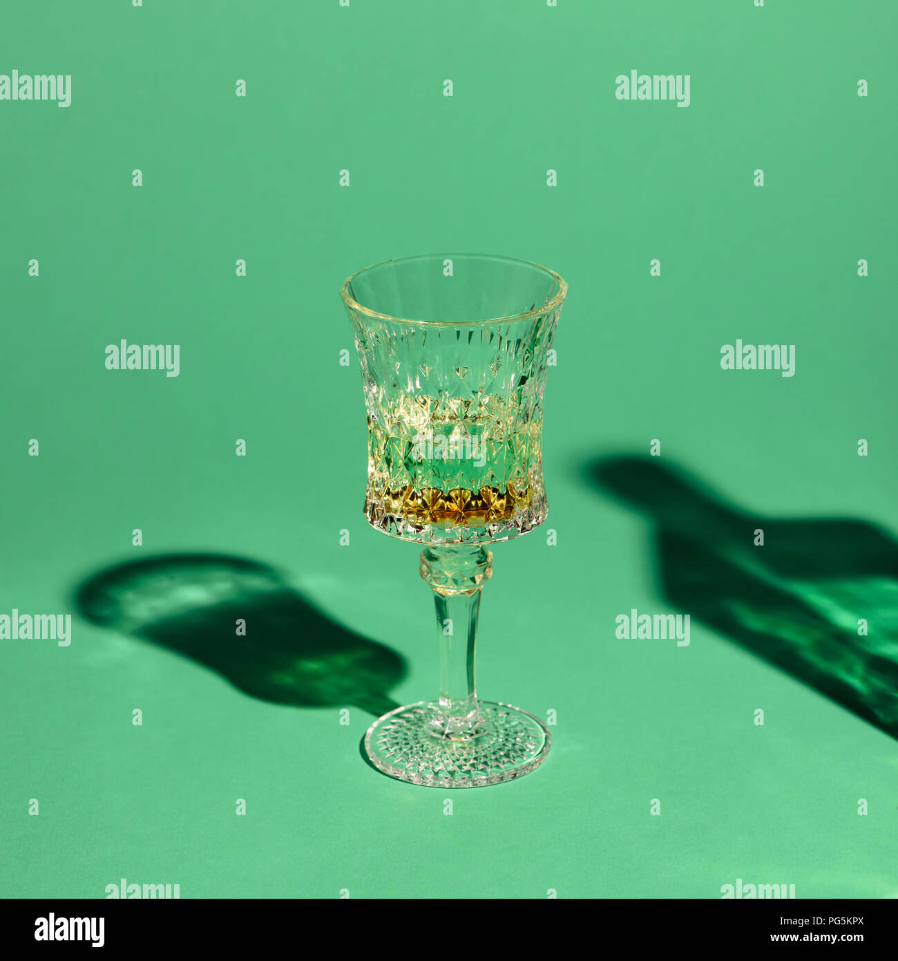 close-up shot of crystal glass of absinthe on green surface Stock Photo