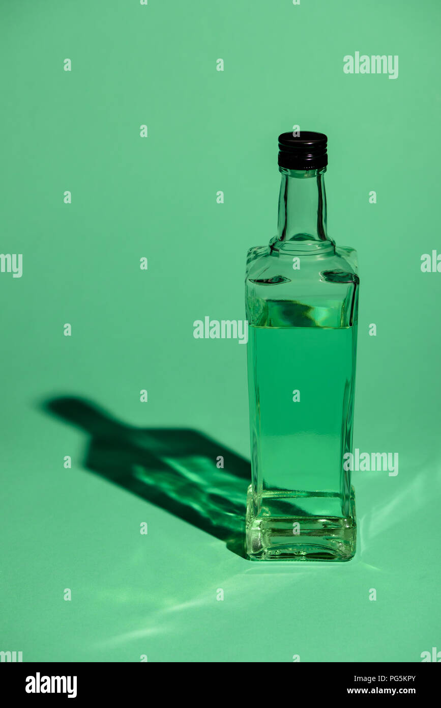 glass bottle of absinthe on green surface Stock Photo