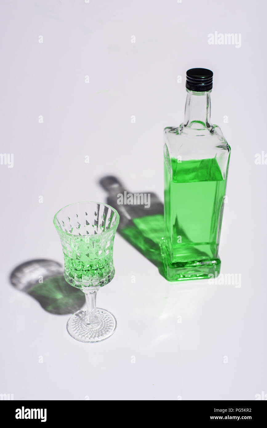 crystal glass and bottle of absinthe on white Stock Photo