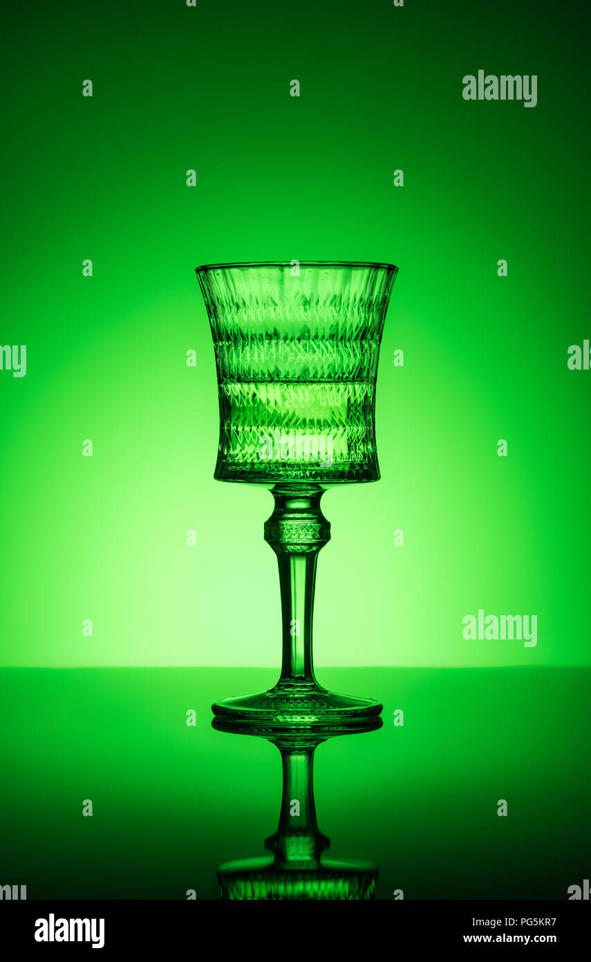 lead glass of absinthe on reflective surface and dark green background Stock Photo
