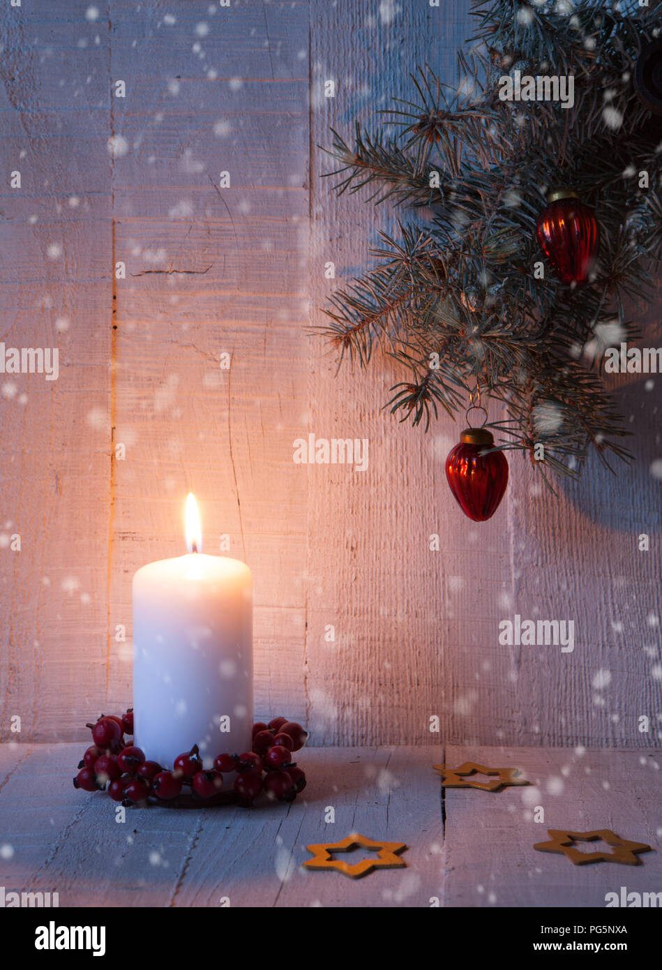 Fir branch, candle and  Christmas decorations on the old  wooden plank. Stock Photo