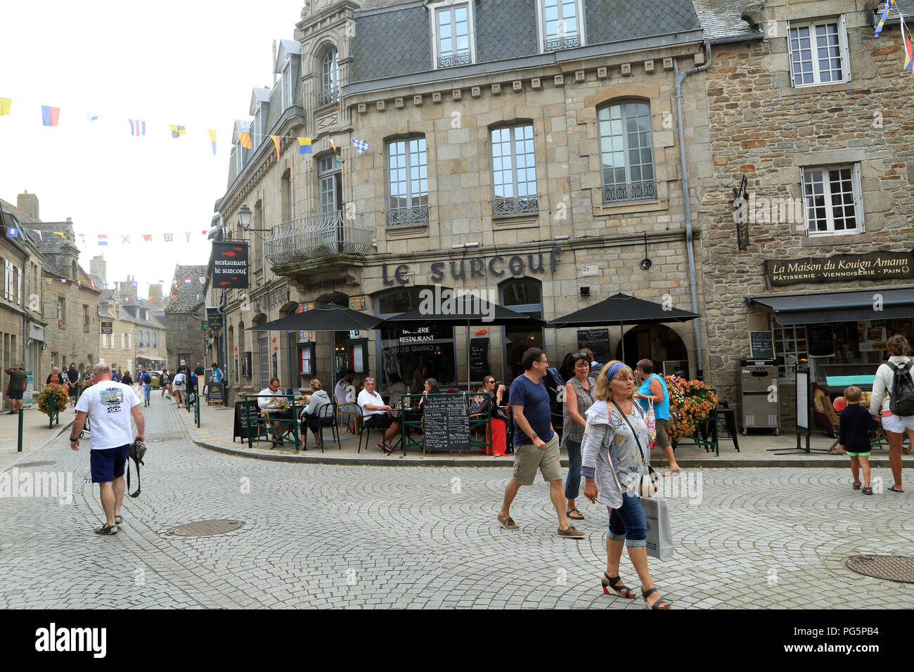 Restaurant and shoppers on corner of Rue Armand Rousseau and Rue Admiral Reveillere, Roscoff, Finistere, Brittany, France Stock Photo