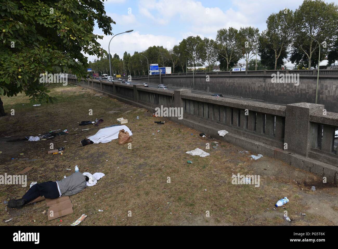 August 14, 2018 - Paris, France: Migrants sleep in a public park near the  peripherique (ring road) between porte de la Chapelle and porte  d'Aubervilliers. Des migrants dorment dans un parc public